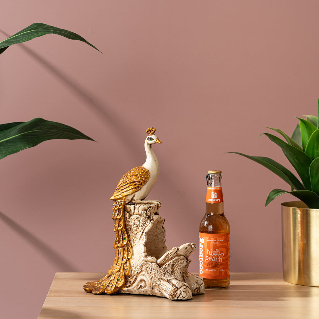 a bird figurine sitting on top of a wooden table next to a beer