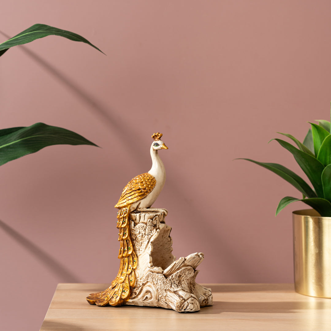 a bird figurine sitting on top of a table next to a potted