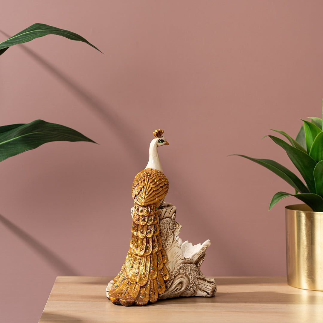 a bird figurine sitting on a table next to a potted plant