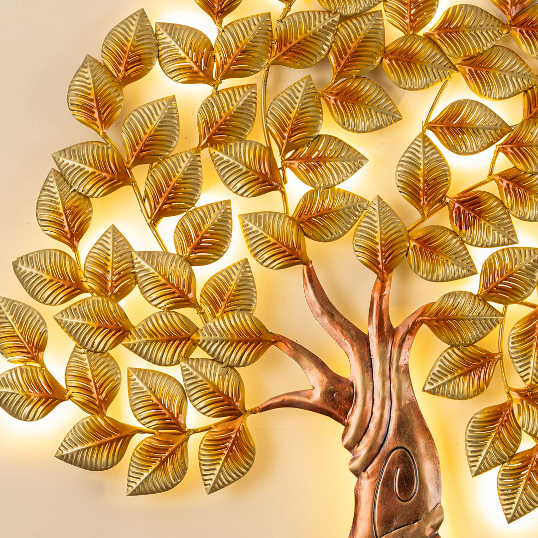 a decorative tree made of gold leaves on a white wall