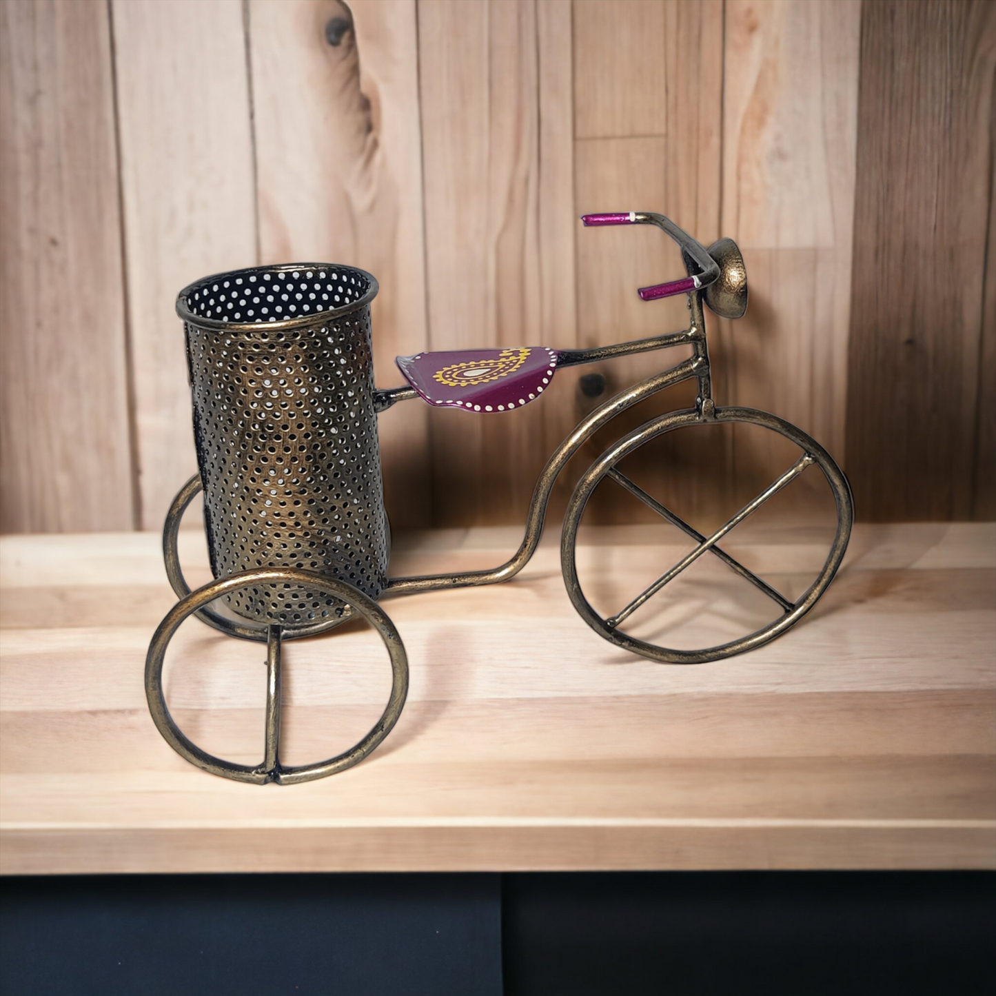 a metal vase sitting on top of a wooden table